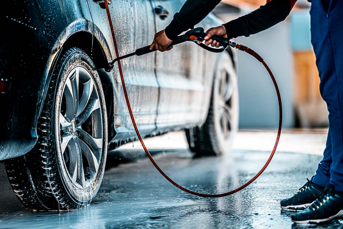 En verkstadstekniker tvättar en bil.